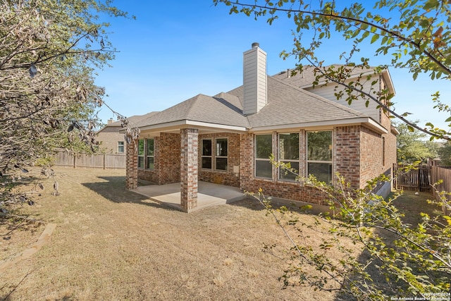 rear view of property featuring a lawn and a patio area