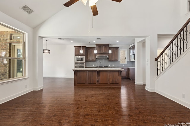 kitchen featuring a center island with sink, dark wood-type flooring, decorative light fixtures, and stainless steel appliances