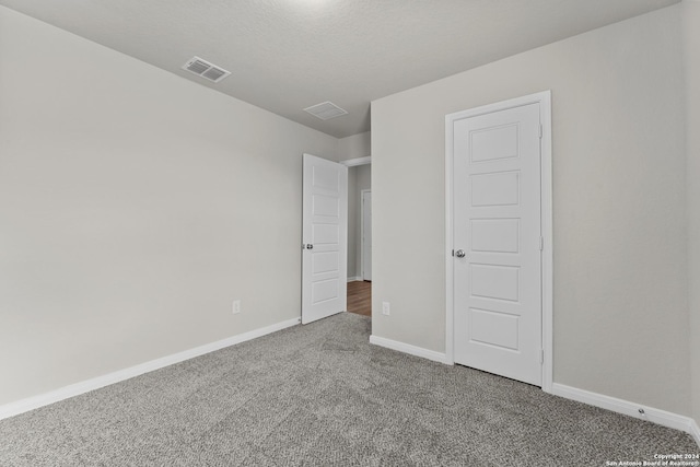 unfurnished bedroom with carpet floors and a textured ceiling