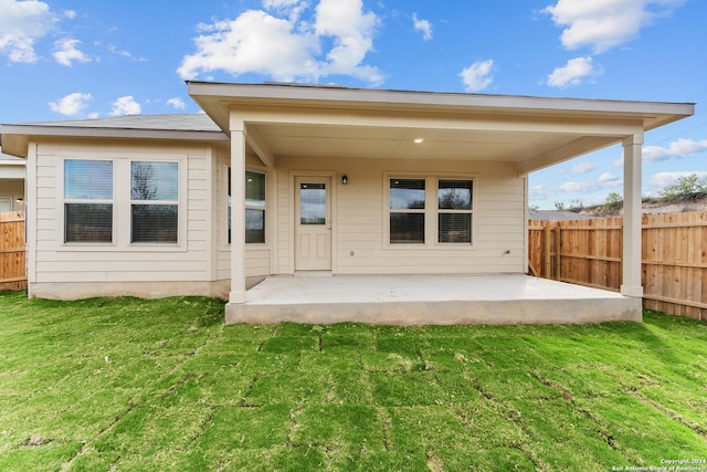 rear view of house with a yard and a patio