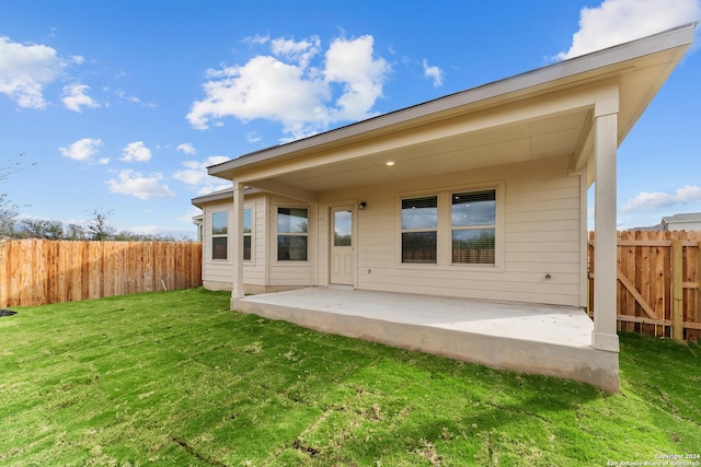 rear view of property with a yard and a patio