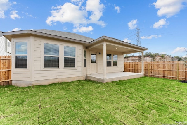 back of property with a lawn and a patio area