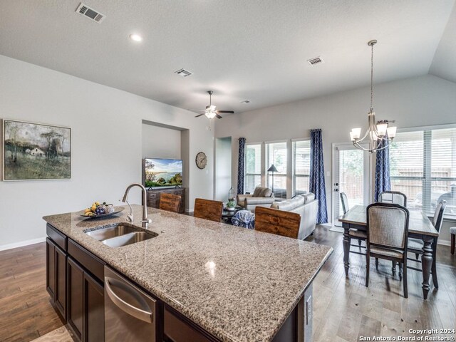 kitchen featuring sink, light stone counters, an island with sink, decorative backsplash, and appliances with stainless steel finishes