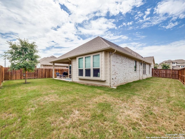 back of property featuring a yard and a patio