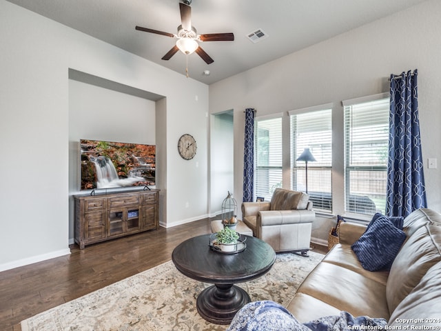 living room featuring ceiling fan and dark hardwood / wood-style flooring