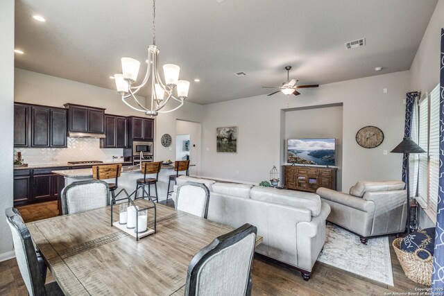 dining room featuring dark hardwood / wood-style floors, vaulted ceiling, and an inviting chandelier