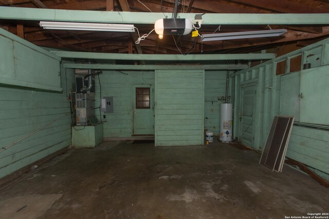 garage featuring electric panel, a garage door opener, and water heater