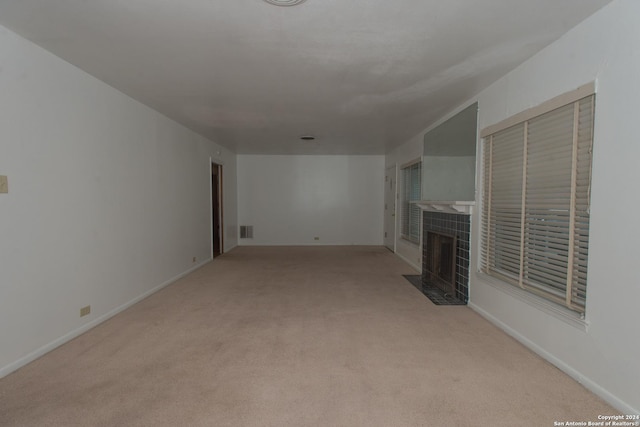 unfurnished living room with a fireplace and light carpet