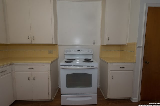 kitchen with white electric range oven, white cabinetry, wood-type flooring, decorative backsplash, and tile countertops