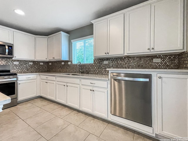 kitchen with white cabinetry, sink, light tile patterned floors, and stainless steel appliances