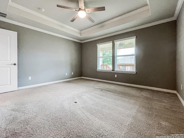 carpeted spare room featuring crown molding, ceiling fan, and a tray ceiling