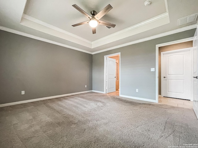 unfurnished bedroom featuring crown molding, light colored carpet, a raised ceiling, and ceiling fan