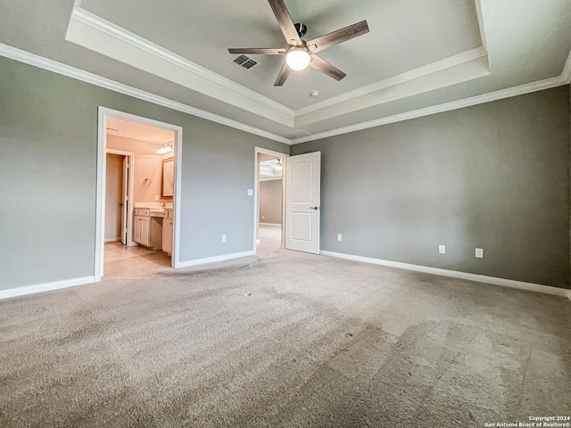 unfurnished bedroom featuring crown molding, ceiling fan, connected bathroom, and a raised ceiling