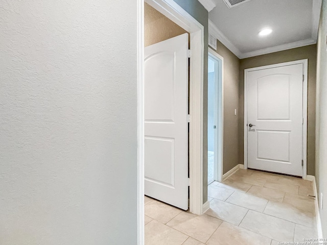 corridor featuring crown molding and light tile patterned floors