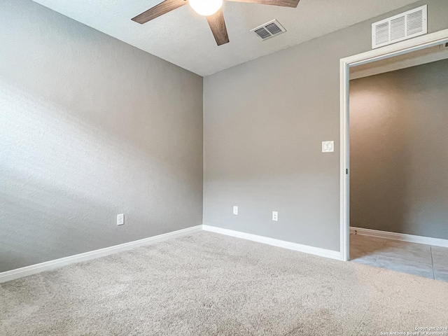 carpeted spare room featuring ceiling fan