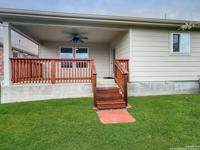 back of house with ceiling fan and a lawn