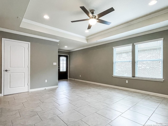 unfurnished room with light tile patterned floors, a tray ceiling, ornamental molding, and ceiling fan