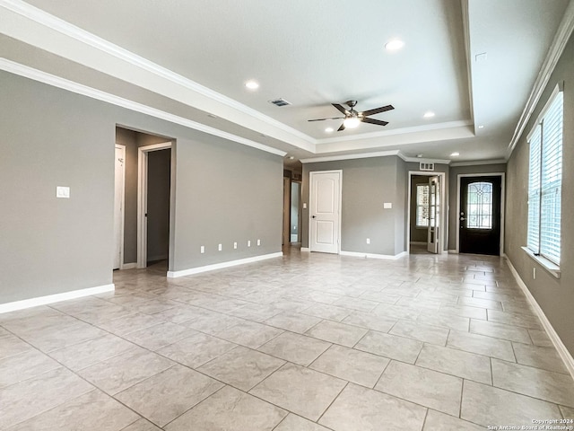 interior space featuring light tile patterned flooring, ceiling fan, ornamental molding, and a raised ceiling