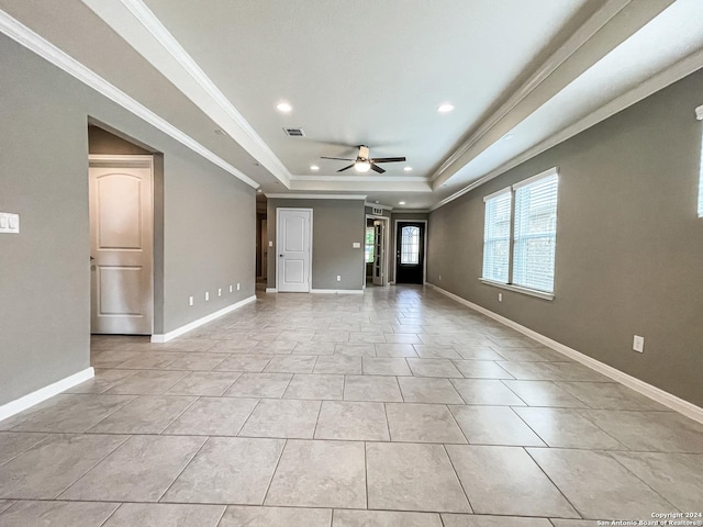 unfurnished room with a raised ceiling, crown molding, light tile patterned flooring, and ceiling fan