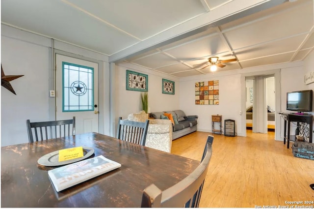 dining area featuring a ceiling fan, coffered ceiling, and wood finished floors