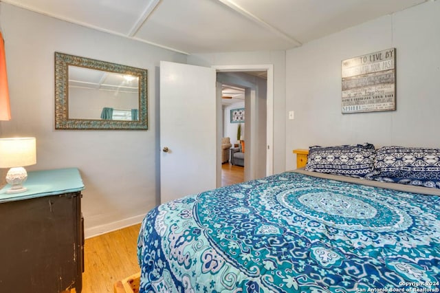 bedroom featuring light wood finished floors and baseboards