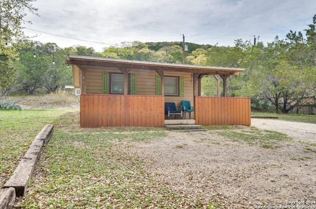 chalet / cabin featuring covered porch and gravel driveway