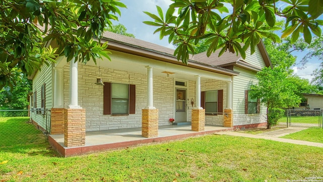 view of property exterior with a porch and a lawn