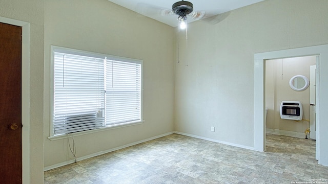 unfurnished room with heating unit, light tile patterned floors, and plenty of natural light