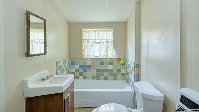 bathroom with vanity, a bath, and toilet