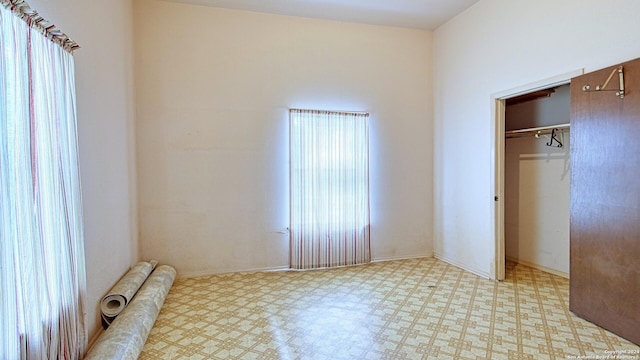 unfurnished bedroom with multiple windows, a closet, and light tile patterned floors