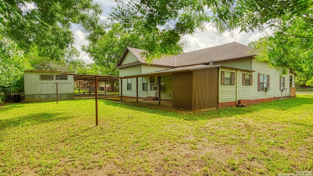 rear view of property with central AC unit and a lawn