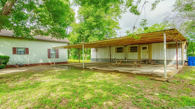 rear view of house featuring a carport and a lawn