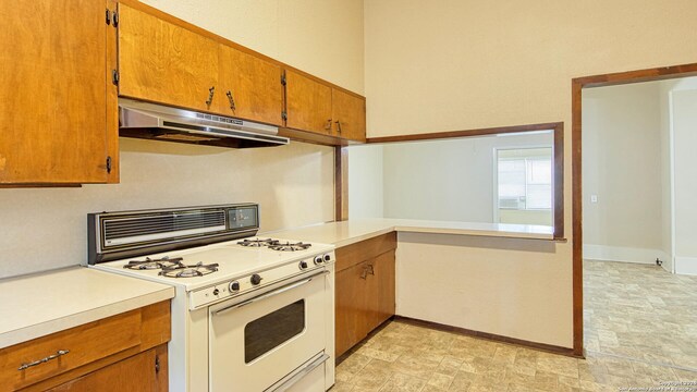 kitchen with light tile patterned floors and white gas range