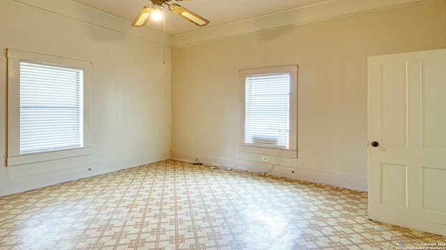 spare room featuring light tile patterned floors, a wealth of natural light, and ceiling fan