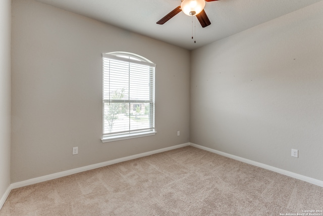 unfurnished room with light colored carpet and ceiling fan