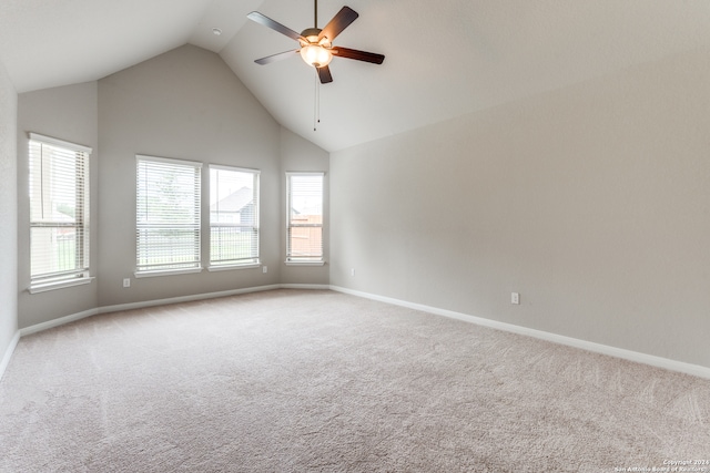 carpeted empty room with ceiling fan and high vaulted ceiling