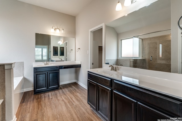 bathroom with hardwood / wood-style flooring, separate shower and tub, and vanity