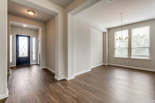 foyer entrance featuring dark wood-type flooring and a chandelier