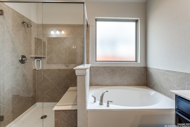 bathroom featuring vanity, shower with separate bathtub, and a wealth of natural light