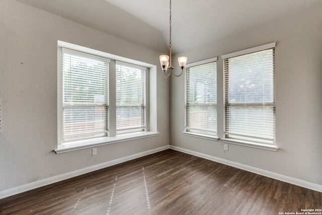 unfurnished room with plenty of natural light, an inviting chandelier, and dark hardwood / wood-style flooring