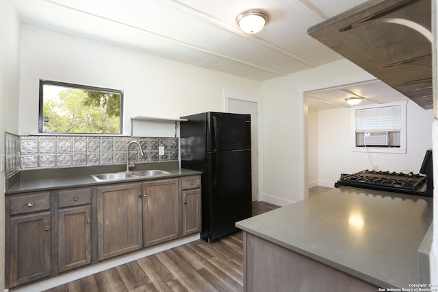 kitchen featuring black refrigerator, sink, decorative backsplash, and dark hardwood / wood-style floors