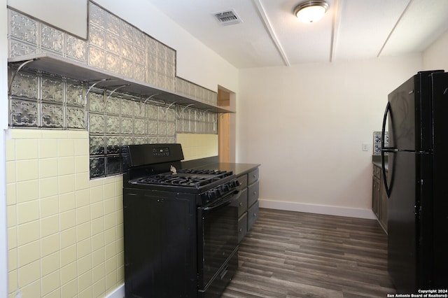 kitchen featuring dark hardwood / wood-style floors, black appliances, and tile walls