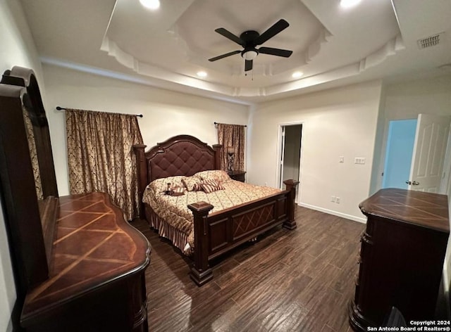 bedroom with ceiling fan and a raised ceiling