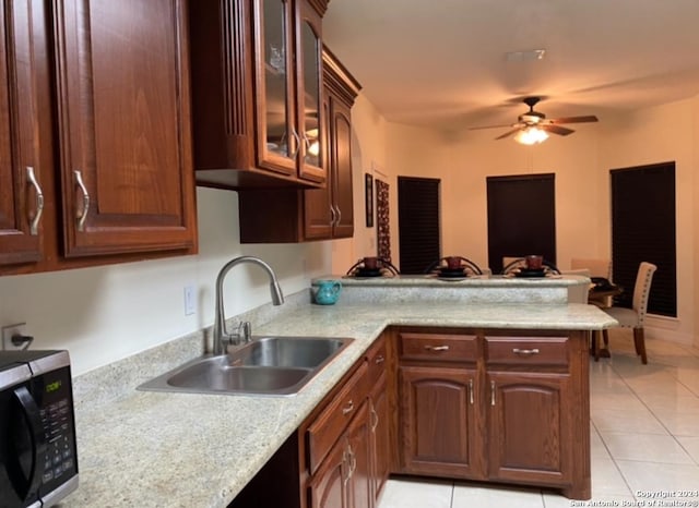 kitchen featuring ceiling fan, sink, light tile patterned floors, and kitchen peninsula