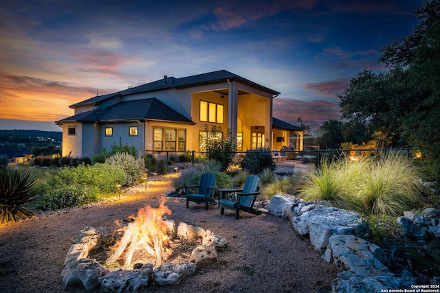 back house at dusk with a fire pit