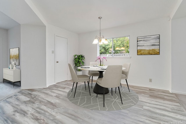 dining room with a notable chandelier and light wood-type flooring