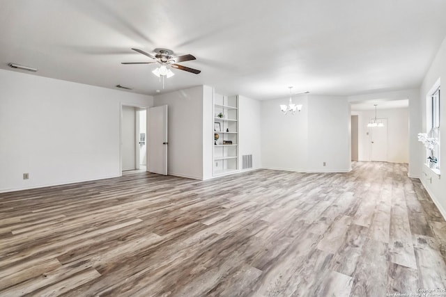 unfurnished living room featuring ceiling fan with notable chandelier and light wood-type flooring