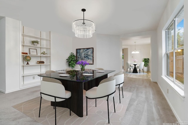 dining room featuring light carpet and a chandelier