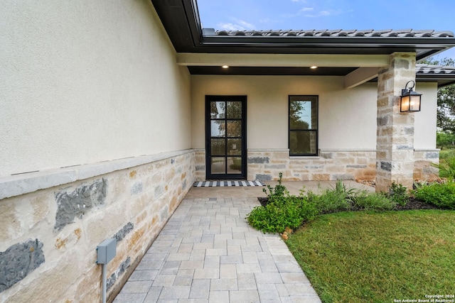 doorway to property with a lawn