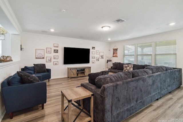 living room with ornamental molding and light hardwood / wood-style flooring